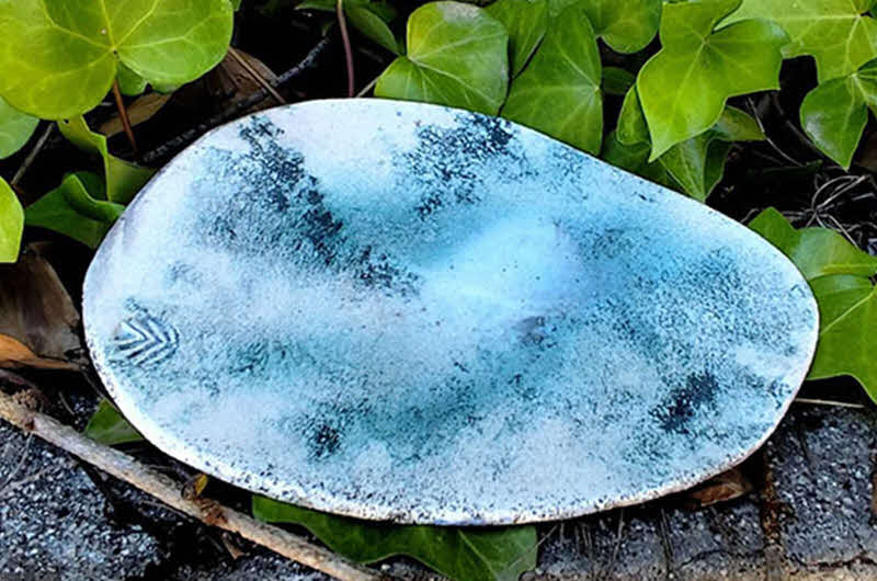 Image of ceramic artwork in foliage