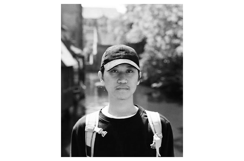 Black and white portrait photograph of a man with a cap